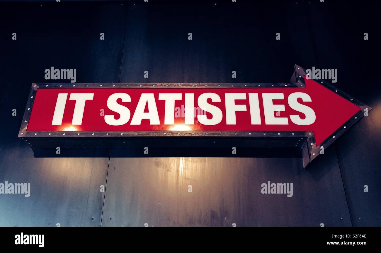decorative arrow with sign It Satisfies in the restaurant - Smartphone Captured Stock Image