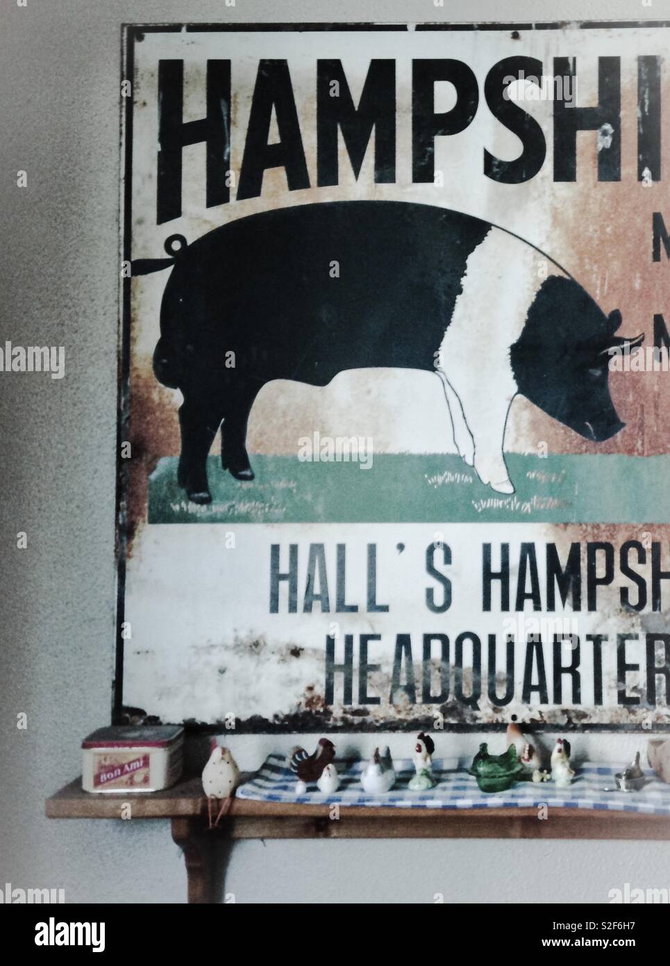 Decorative hog sign with country trinkets below on shelf - Smartphone Captured Stock Image