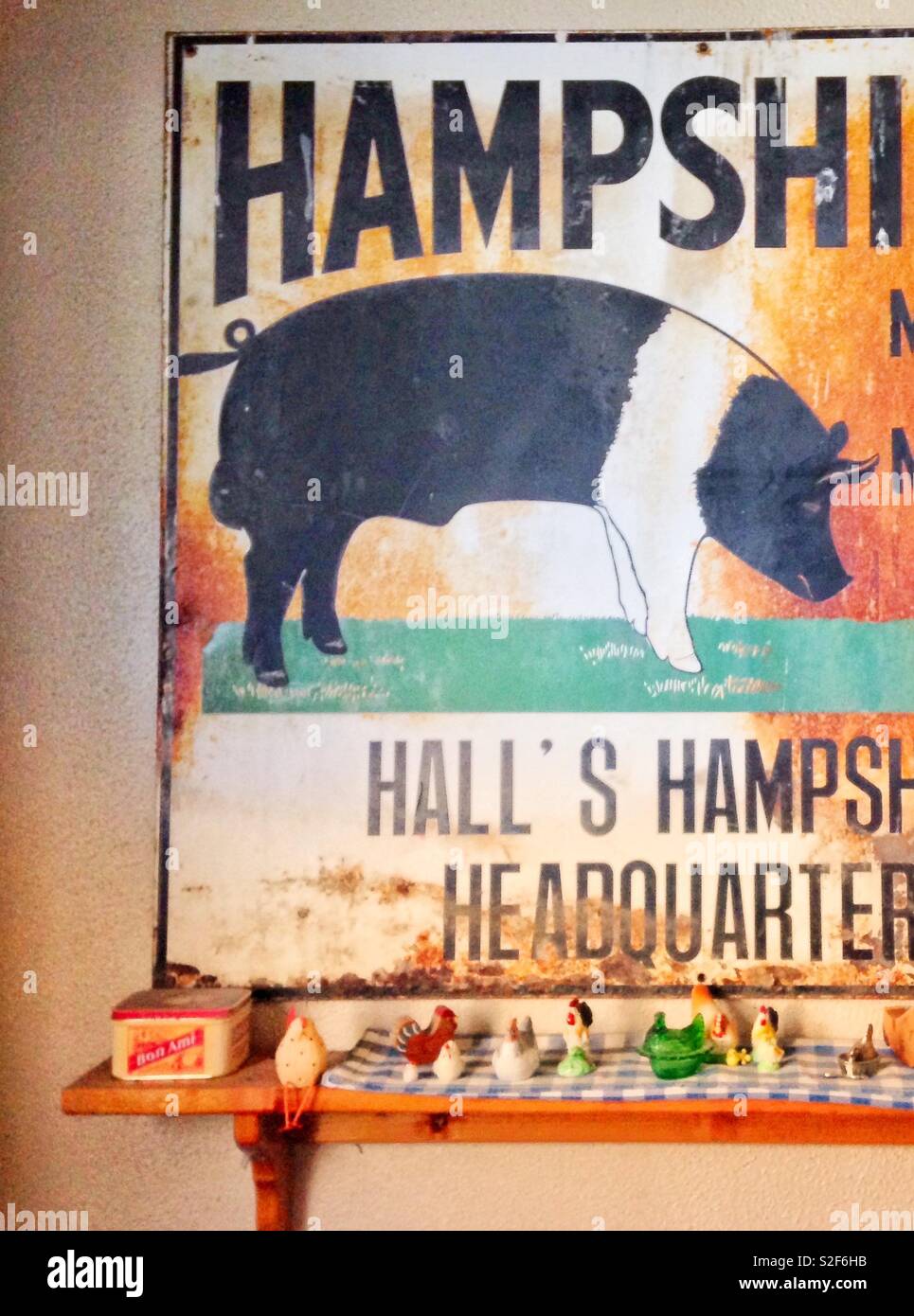 Sunny photo of rusted decorative Hog sign with shelf of country collectibles - Smartphone Captured Stock Image