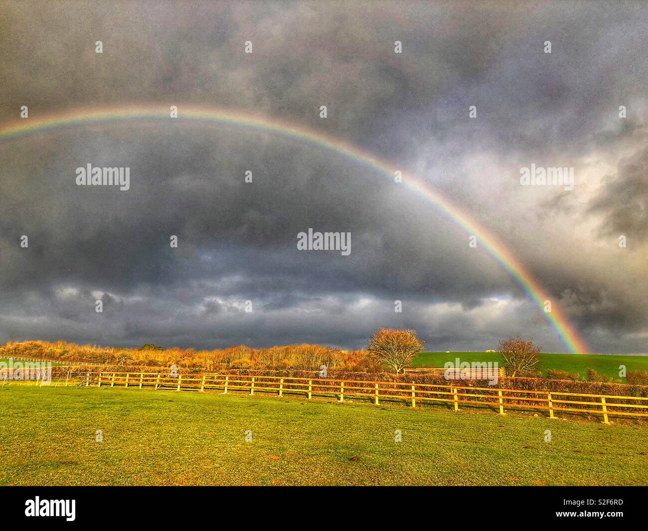 Rainbow and storm clouds over pasture fields, Kingsdon, Somerset, UK Stock Photo