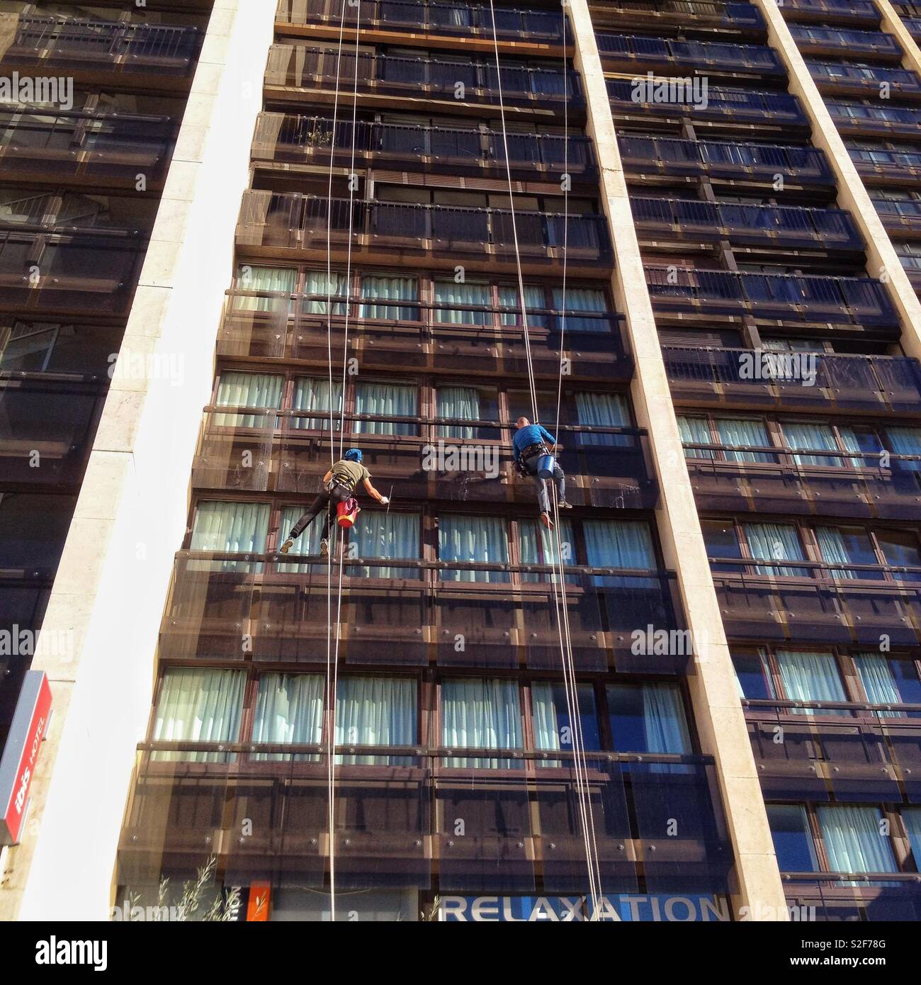 Window washers, acrobatic work - Smartphone Captured Stock Image
