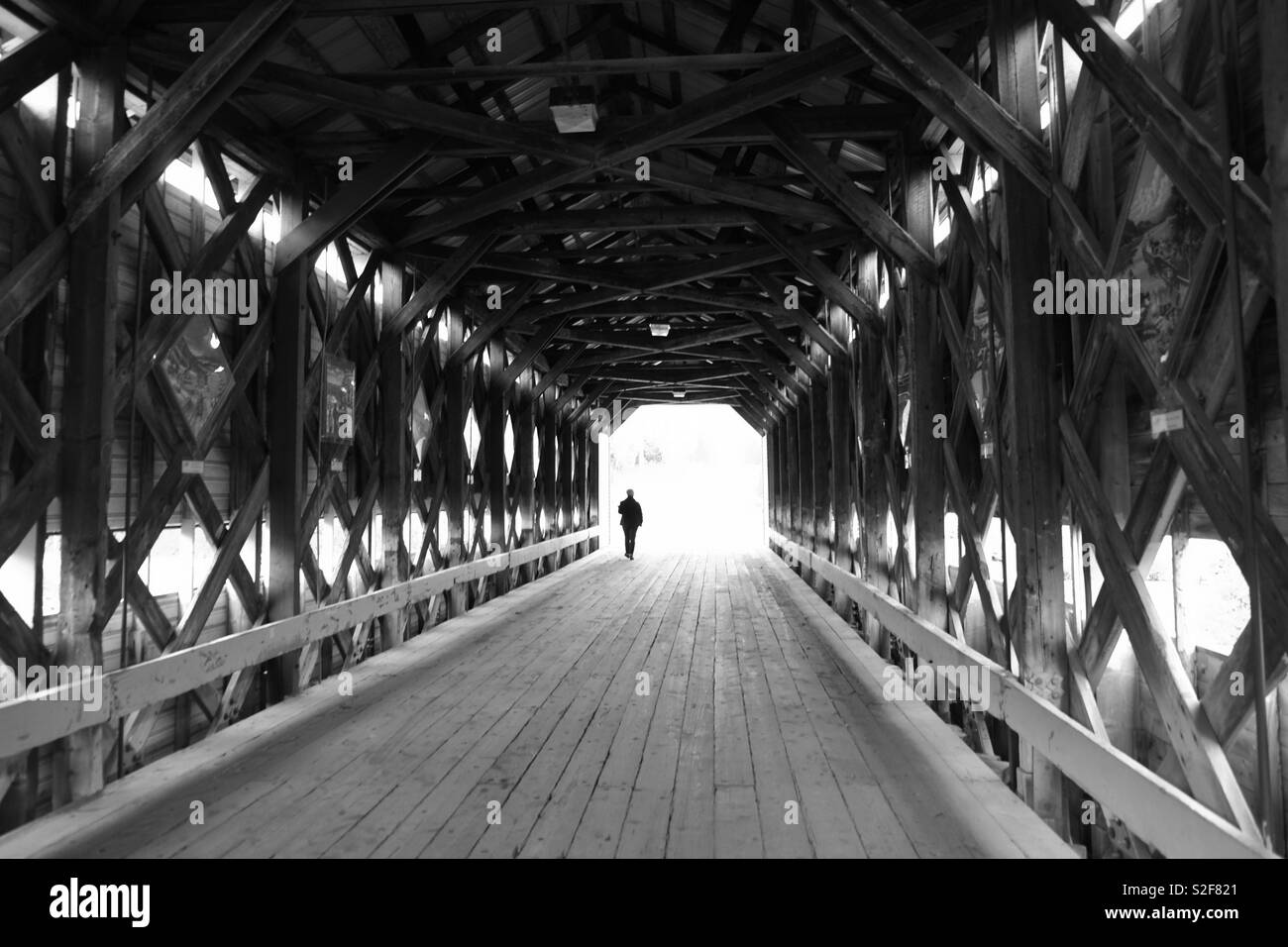 Black and White covered bridge with person walking Stock Photo - Alamy