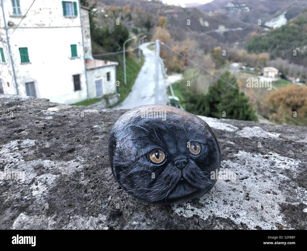 Stone cat over an ancient wall at Castel Trosino, medieval longobard origin village, Ascoli Piceno County,Marche region, Italy - Smartphone Captured Stock Image