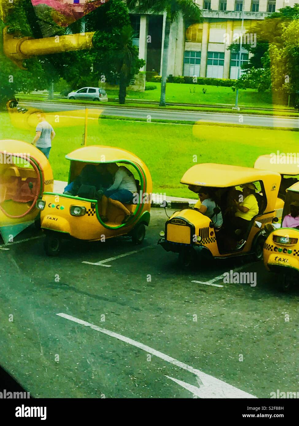 Miniature bright yellow taxi cabs, tuk tuks in Havana Cuba Stock Photo