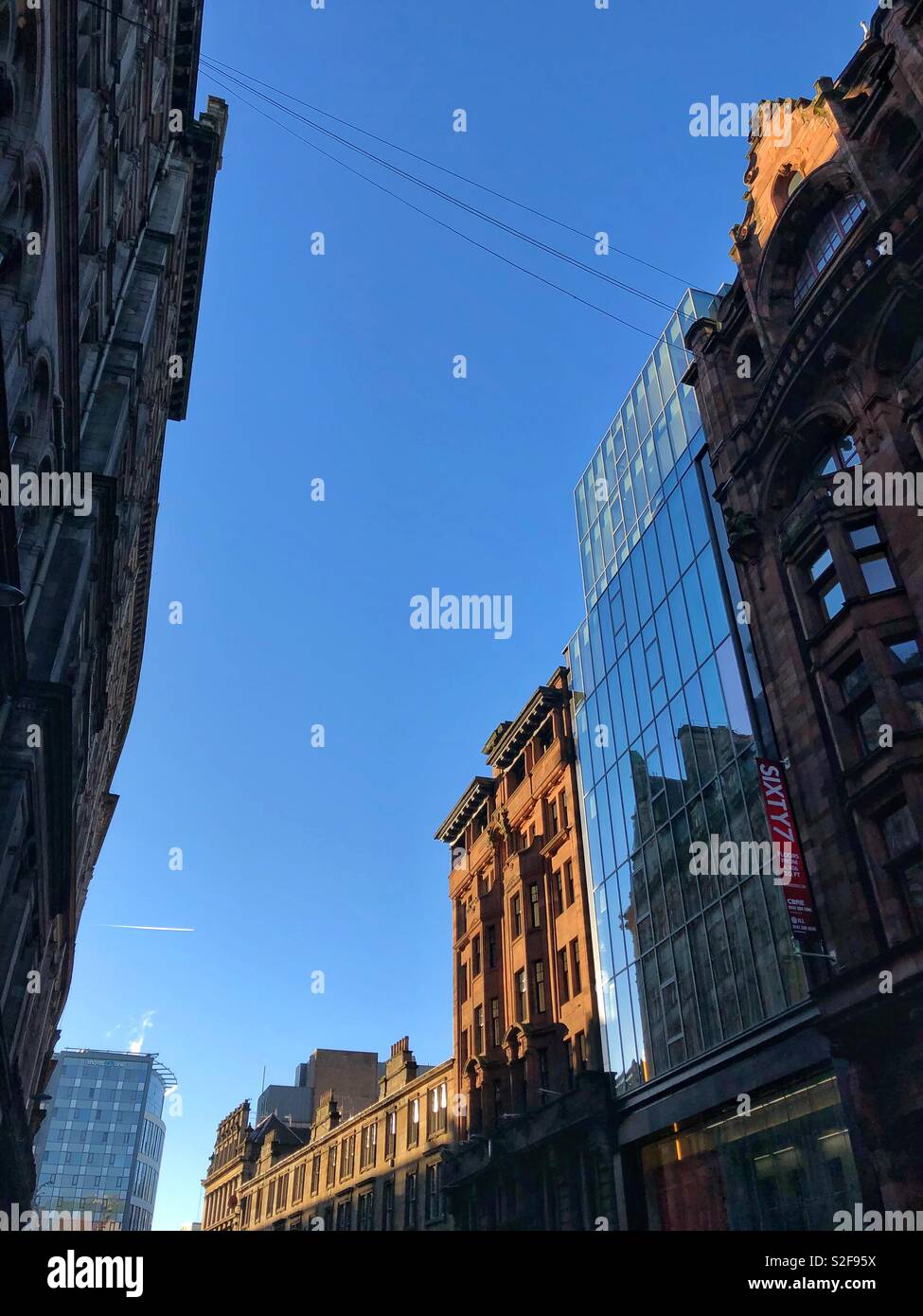 Looking up at buildings in Hope Street, Glasgow city centre, Scotlandon a sunny day.  Contrast between modern and Victorian architecture side by side. - Smartphone Captured Stock Image