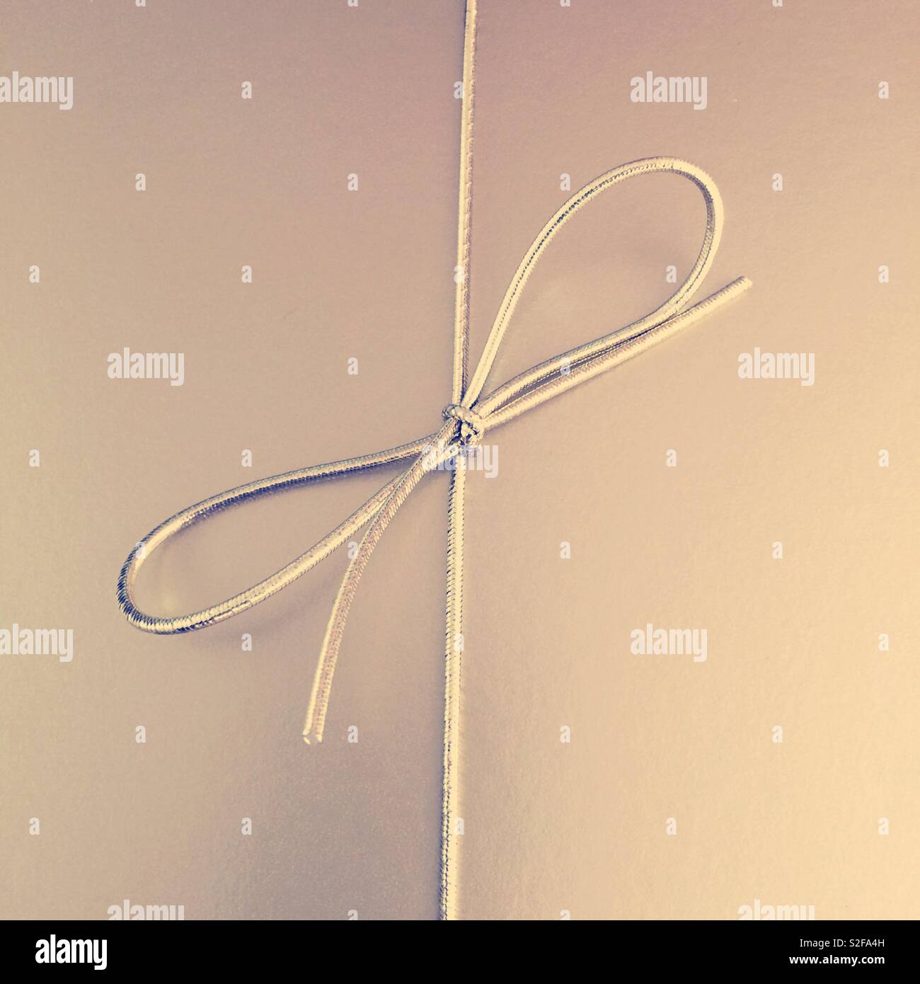 A luxury gold wrapped gift with ribbon Stock Photo