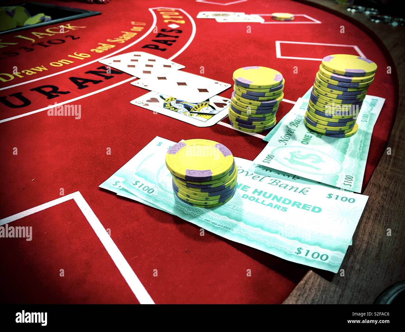 Chips. pretend money and playing cards on a blackjack table. Stock Photo