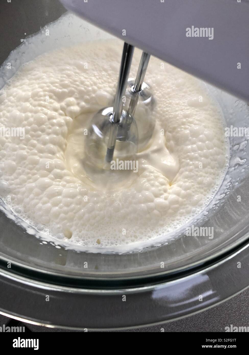 Double cream being whisked with an electric mixer Stock Photo - Alamy