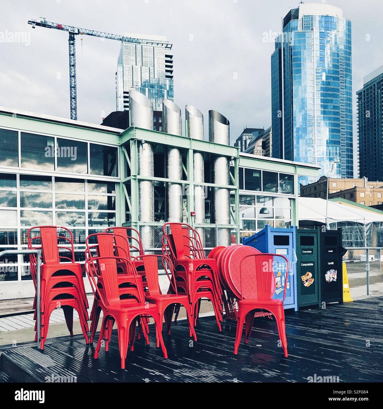Stacked red chairs outside on a deck behind Seattle downtown Stock Photo