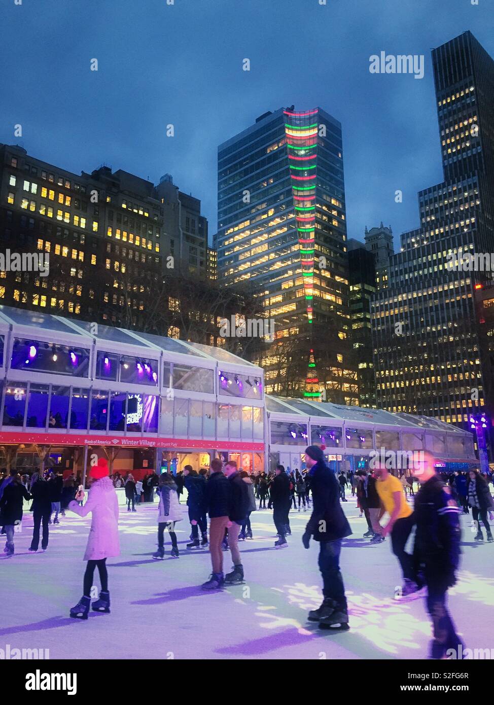 People enjoying the skating rink at Winterfest in Bryant Park, holiday season, New York City, United States - Smartphone Captured Stock Image