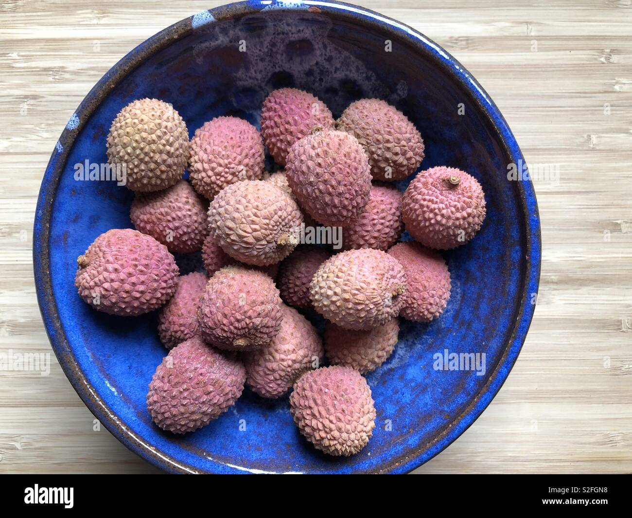 Lychees in a blue ceramic bowl Stock Photo