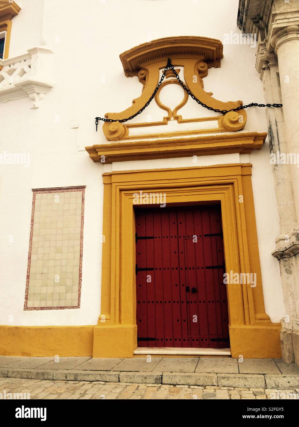 Red door with ornate design above in Maestranza bullring in Seville Spain Stock Photo