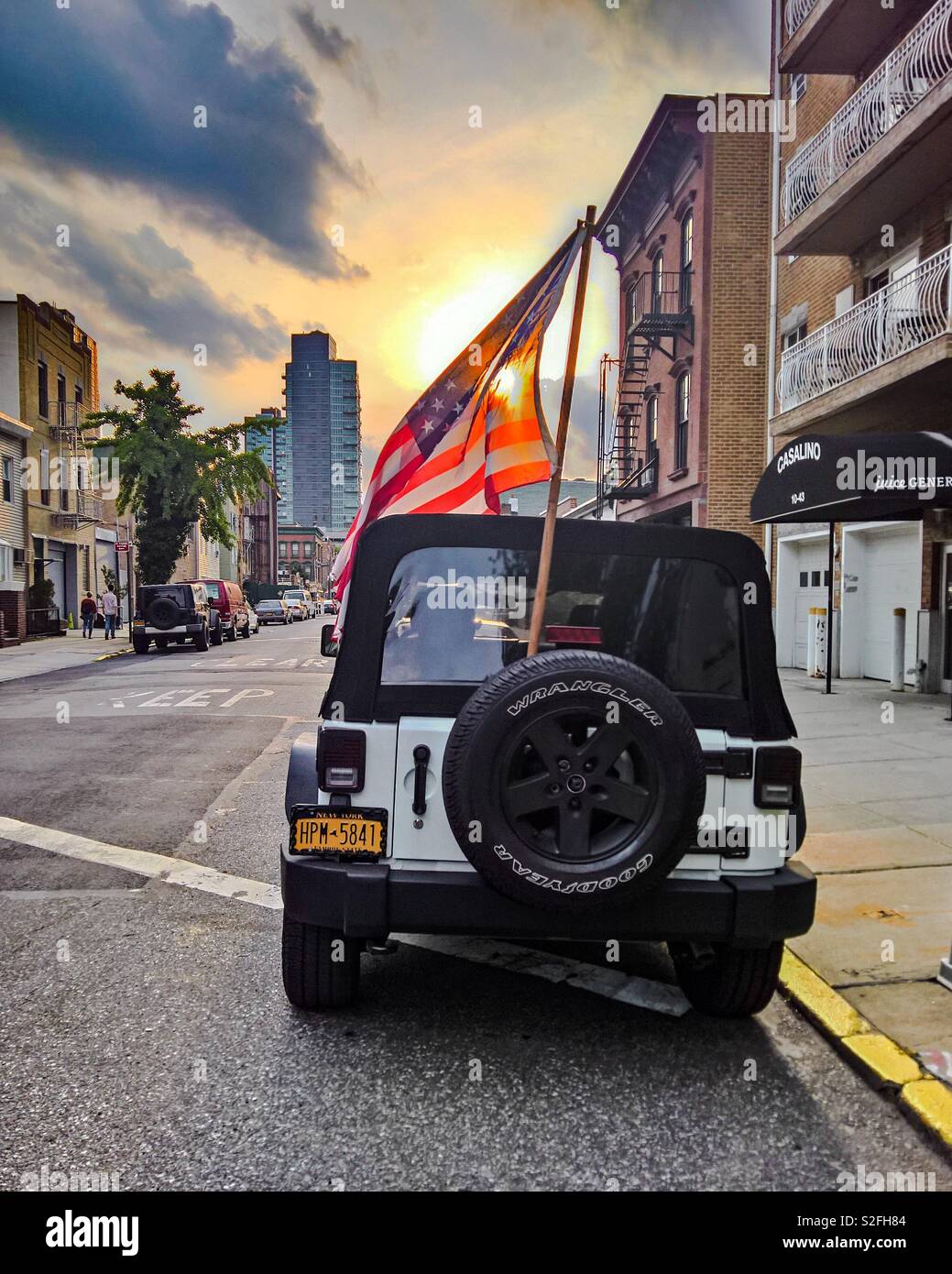 American flag at the back of a Jeep car against the sunset Stock Photo
