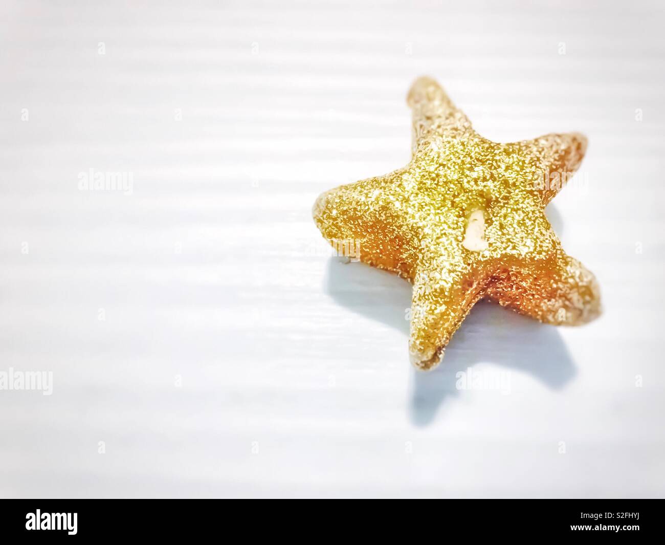 Shiny golden star shaped candle - Smartphone Captured Stock Image