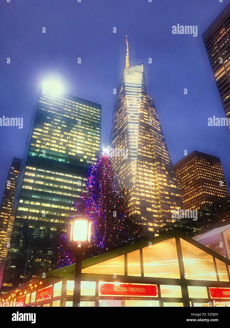 Skyscrapers surround the holiday market in Bryant Park during the Christmas season at dusk, NYC, USA - Smartphone Captured Stock Image