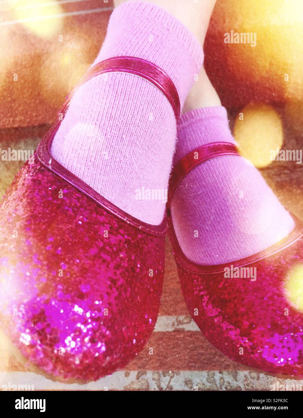 Closeup pink glittery girls dance shoe with pink socks and lens