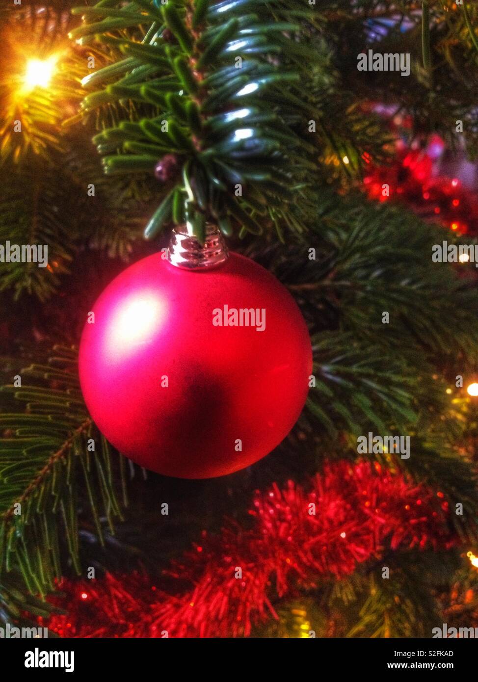 Red Glass Bauble Decoration And Tinsel On A Christmas Tree Stock