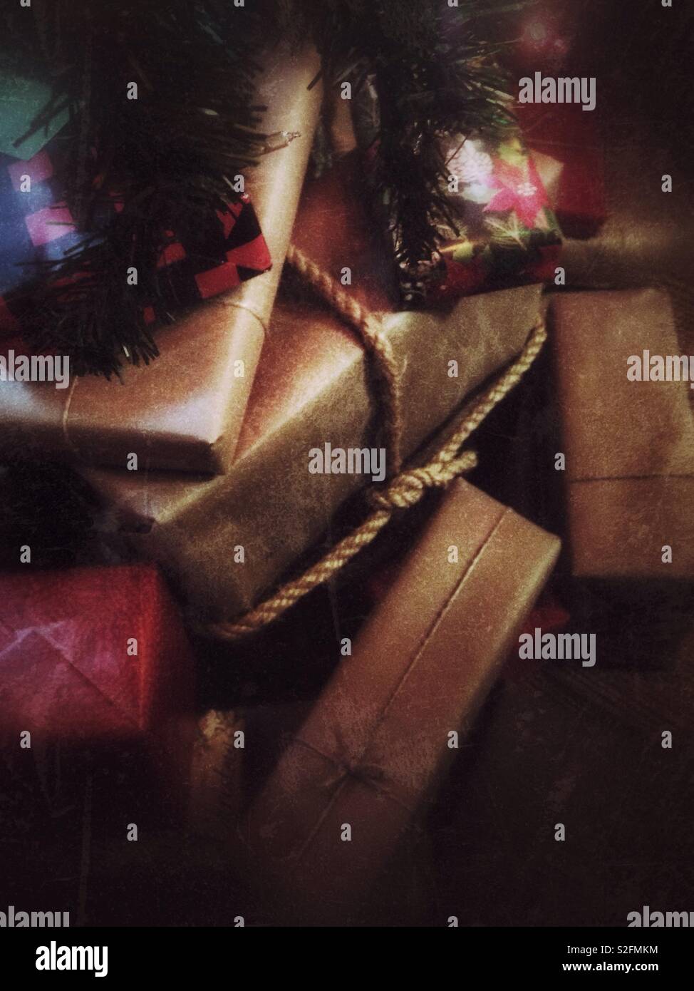 Soft grunge effect on photo of gifts wrapped in brown paper with string under a Christmas tree - Smartphone Captured Stock Image