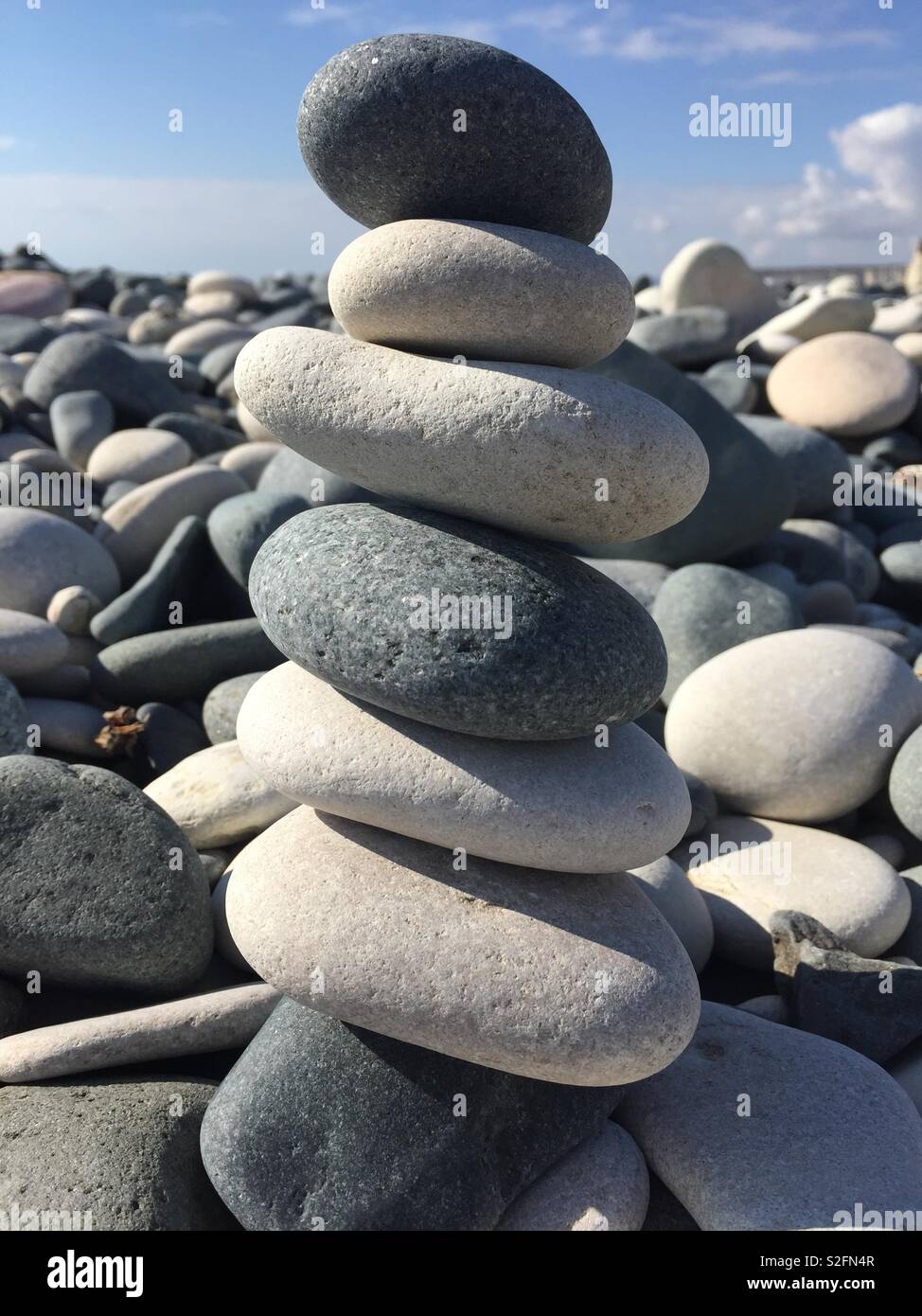 Pile of flat rocks on stony beach Stock Photo