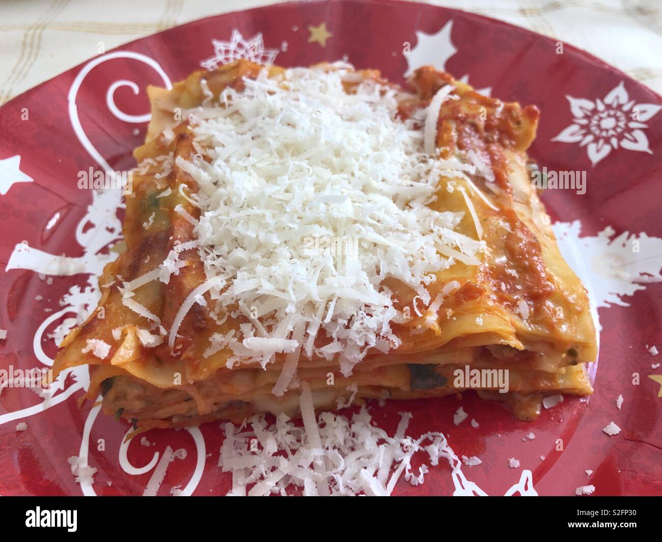 Christmas meal in Italy, a dish of lasagne with much grated cheese - Smartphone Captured Stock Image