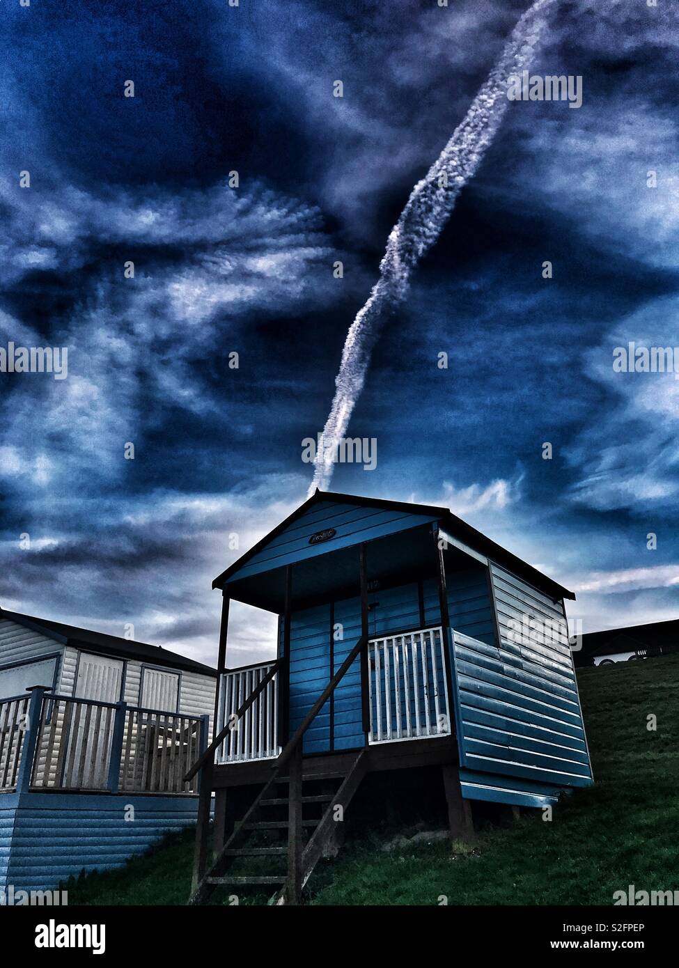 Beach hut with vapour trail - Smartphone Captured Stock Image