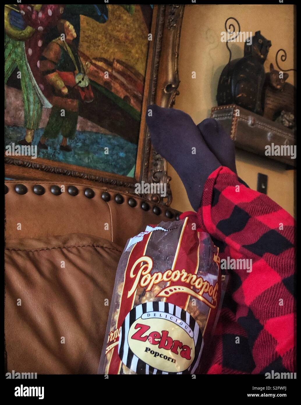 Lazy Day On The Couch In Pajamas Eating Popcorn Stock Photo
