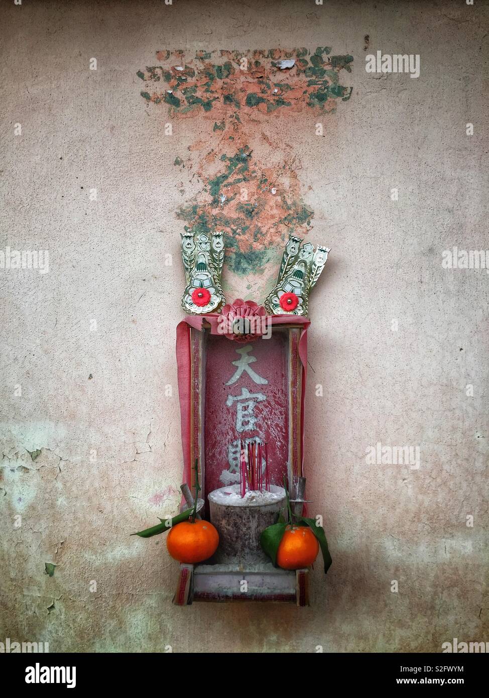 A small shrine outside an old shop house in Kam Tin, New Territories, Hong Kong - Smartphone Captured Stock Image A small shrine outside an old shop house in Kam Tin, New Territories, Hong Kong - Smartphone Captured Stock Image