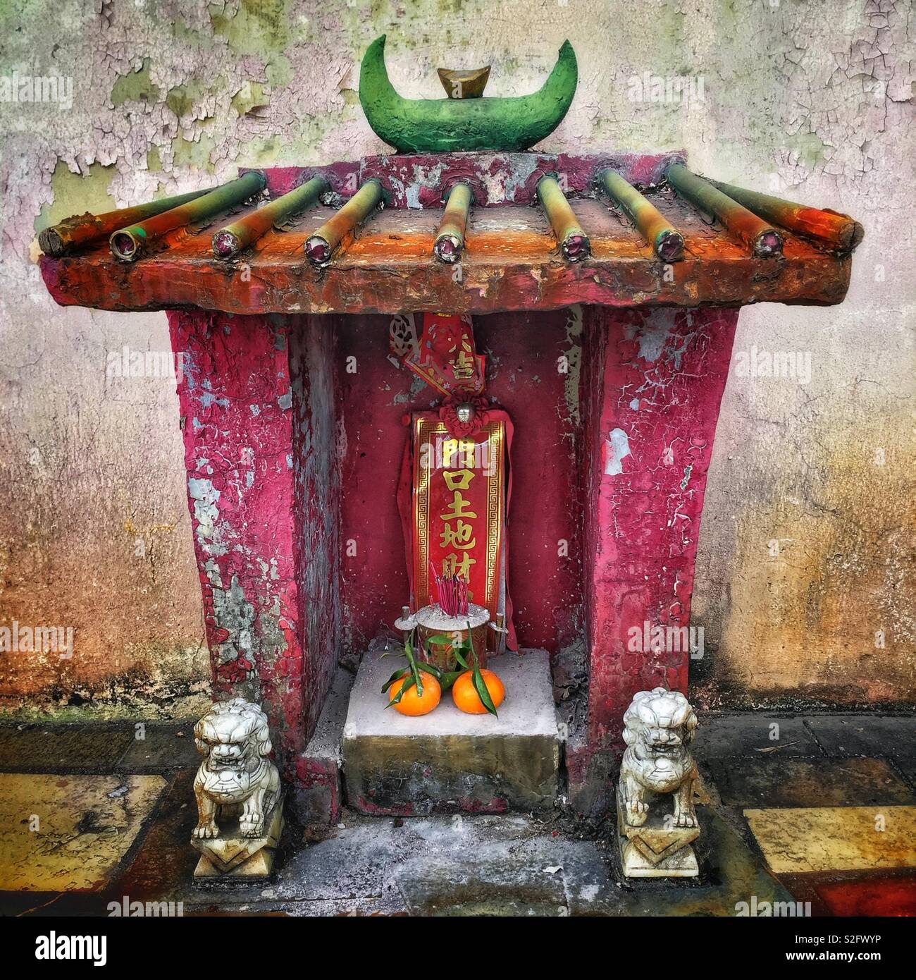 A small shrine outside an old shop house in Kam Tin, New Territories, Hong Kong - Smartphone Captured Stock Image A small shrine outside an old shop house in Kam Tin, New Territories, Hong Kong - Smartphone Captured Stock Image