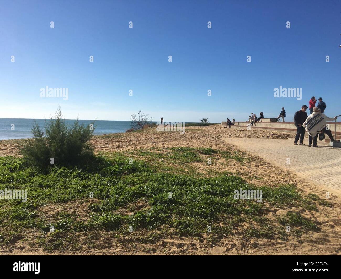 People shooting the breeze having walked the promenade in Quarteira Portugal. - Smartphone Captured Stock Image