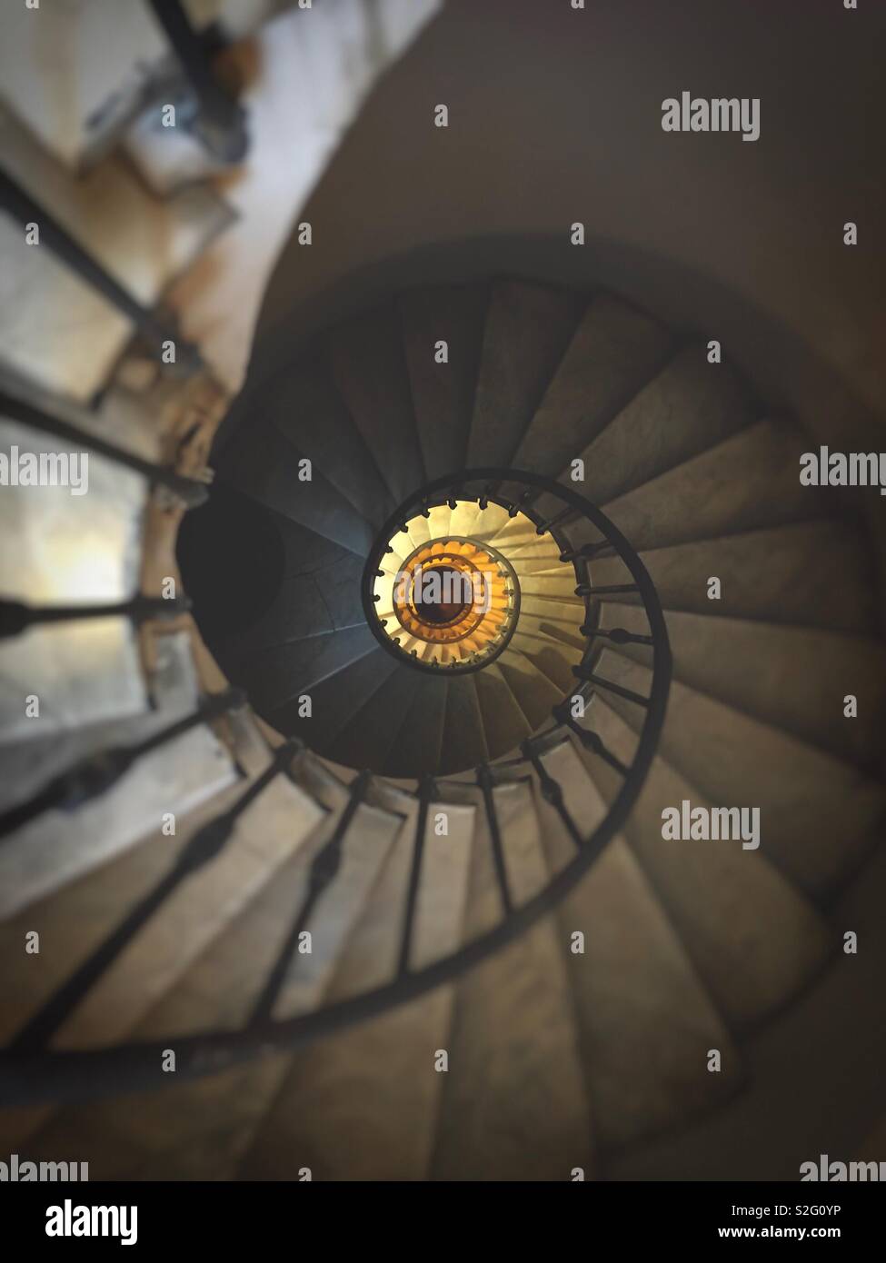 ancient spiral staircase with wrought iron handrail and marble steps - Smartphone Captured Stock Image