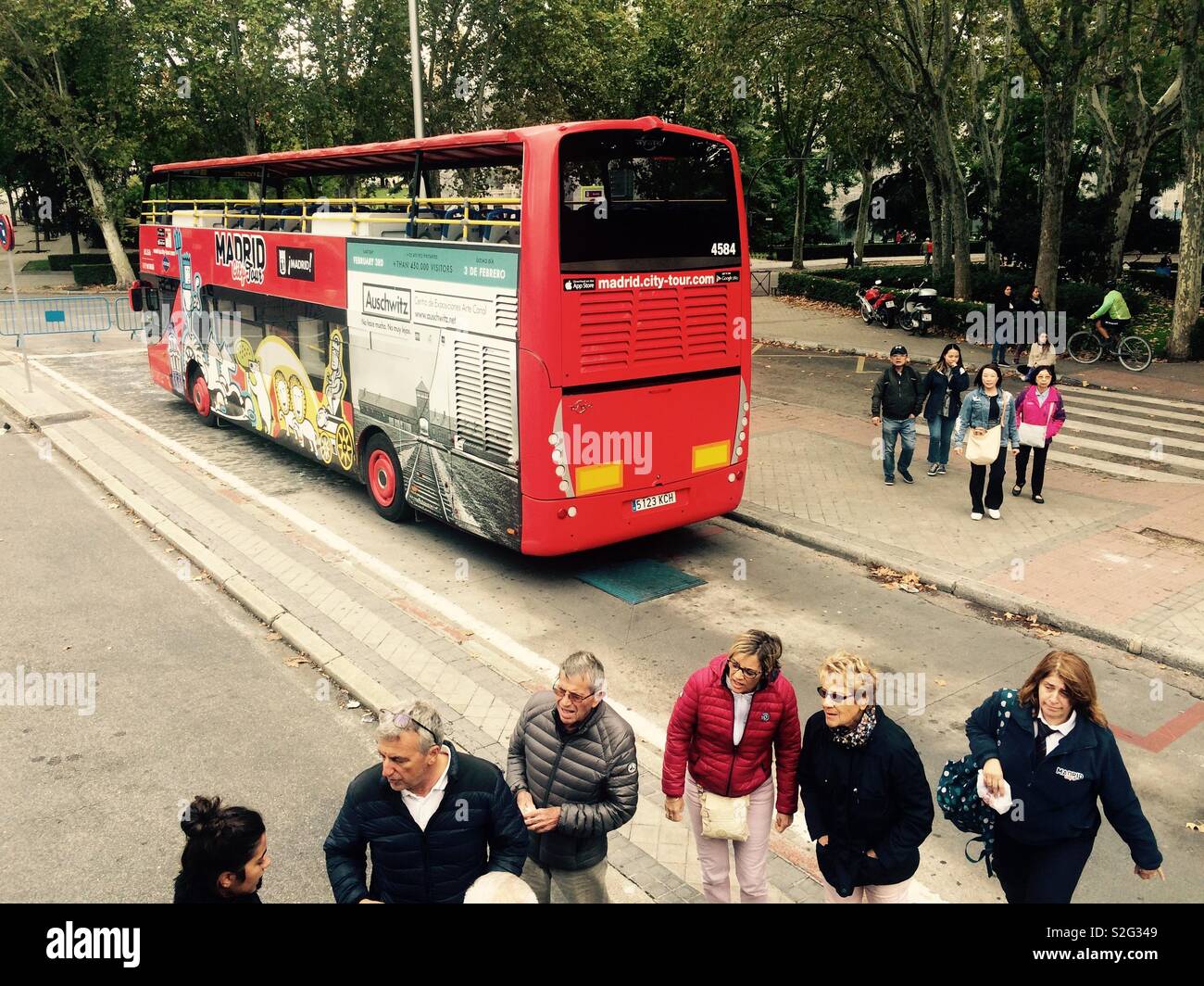 Madrid city tour sightseeing bus parked in public area with people standing around Stock Photo