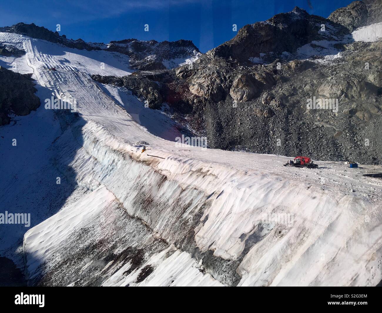 Present glacier covered with fleece fabric to keep from receding to make skiing in winter impossible. Tonale Pass, Adamello min Range, Trentino, Italy. Stock Photo