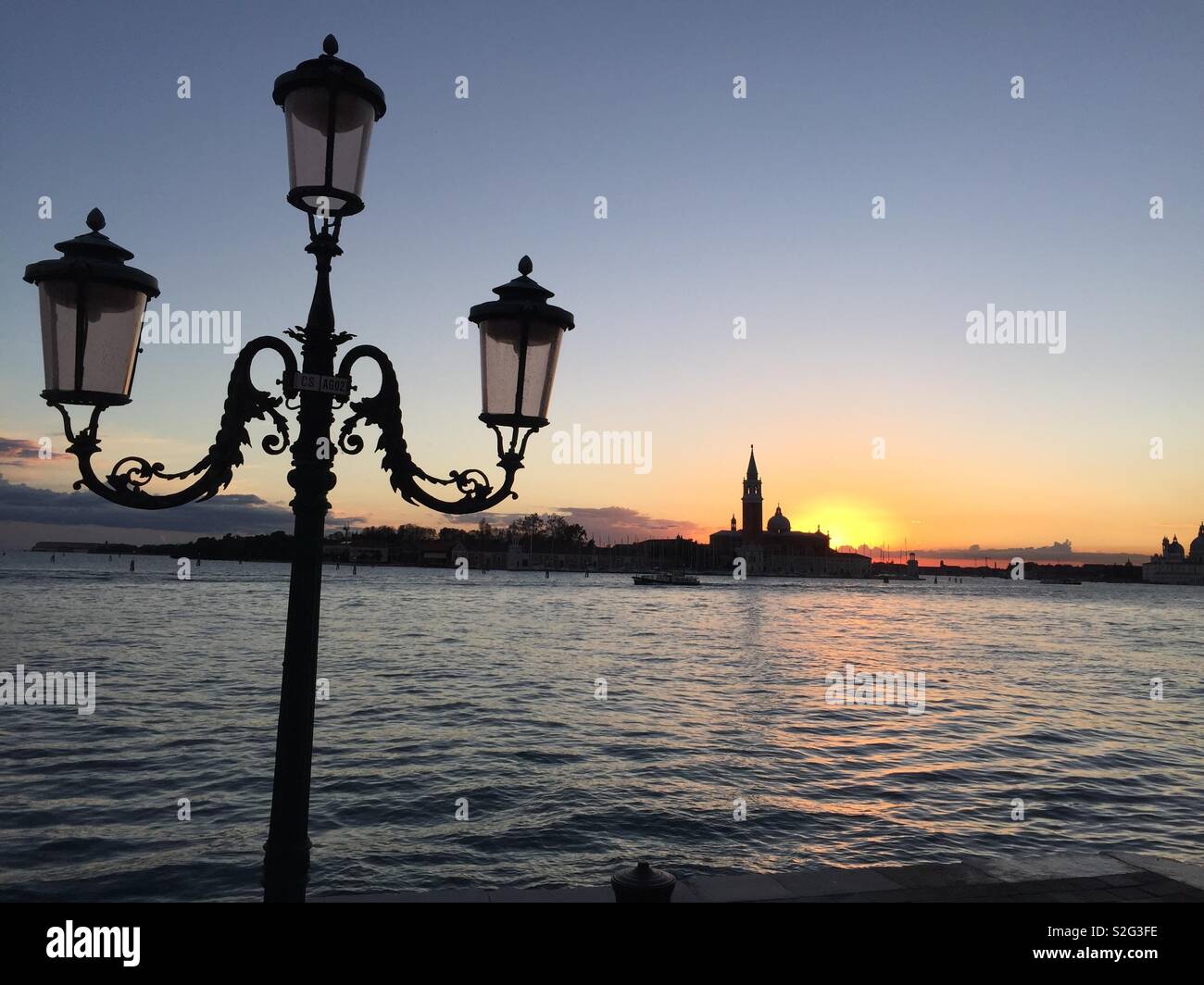 Golden sky over calm waves in the bay Stock Photo - Alamy