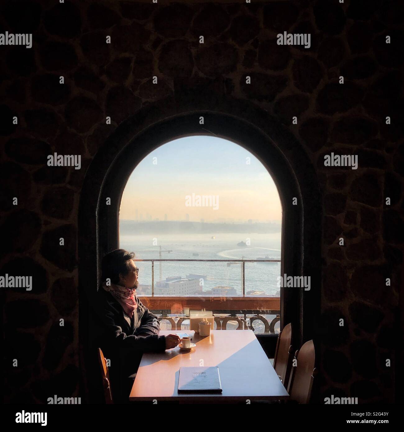 Man looking at view from window of Galata Tower, Turkey - Smartphone Captured Stock Image