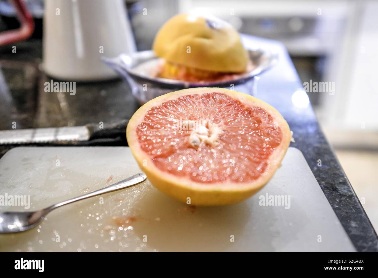 Squeezing fresh grapefruit juice Stock Photo