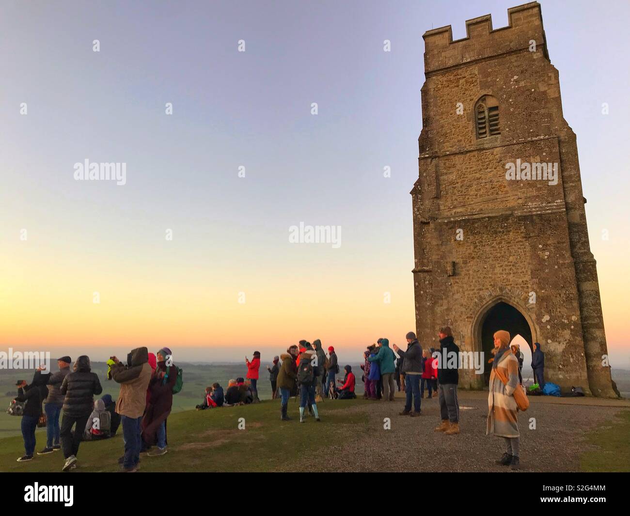Watching sunrise on New Years Day 2019 at Glastonbury Tor, Somerset - Smartphone Captured Stock Image