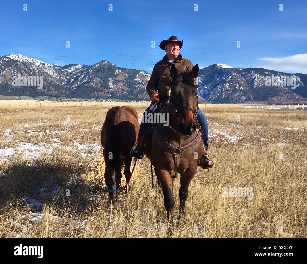 Rancher in Wyoming Leading spare horse Stock Photo