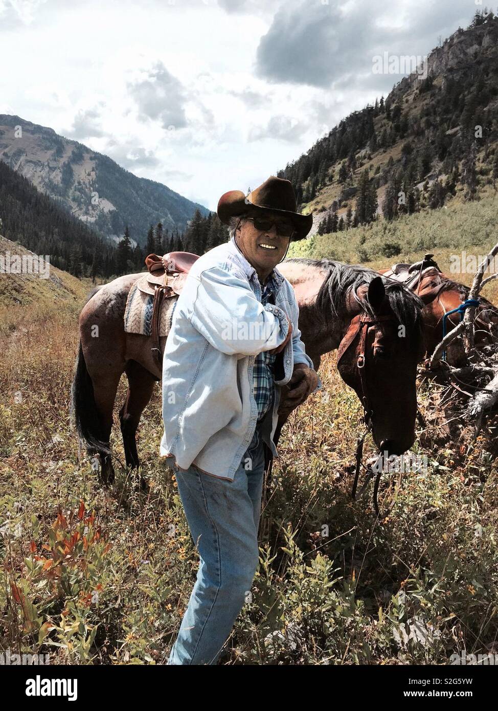 Wyoming rancher on trail ride in grand Teton mountains - Smartphone Captured Stock Image