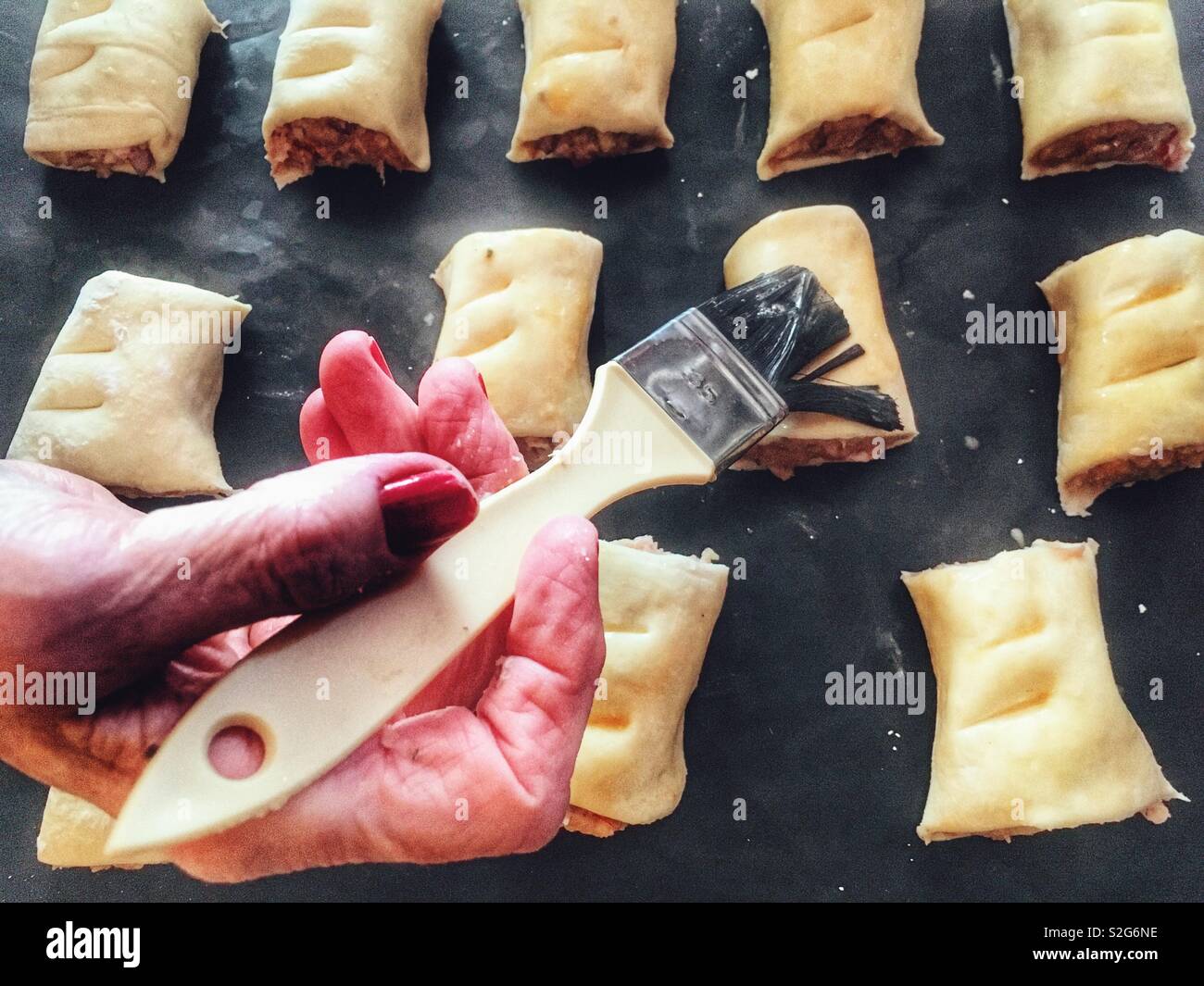 Egg glaze applied to homemade sausage rolls - Smartphone Captured Stock Image