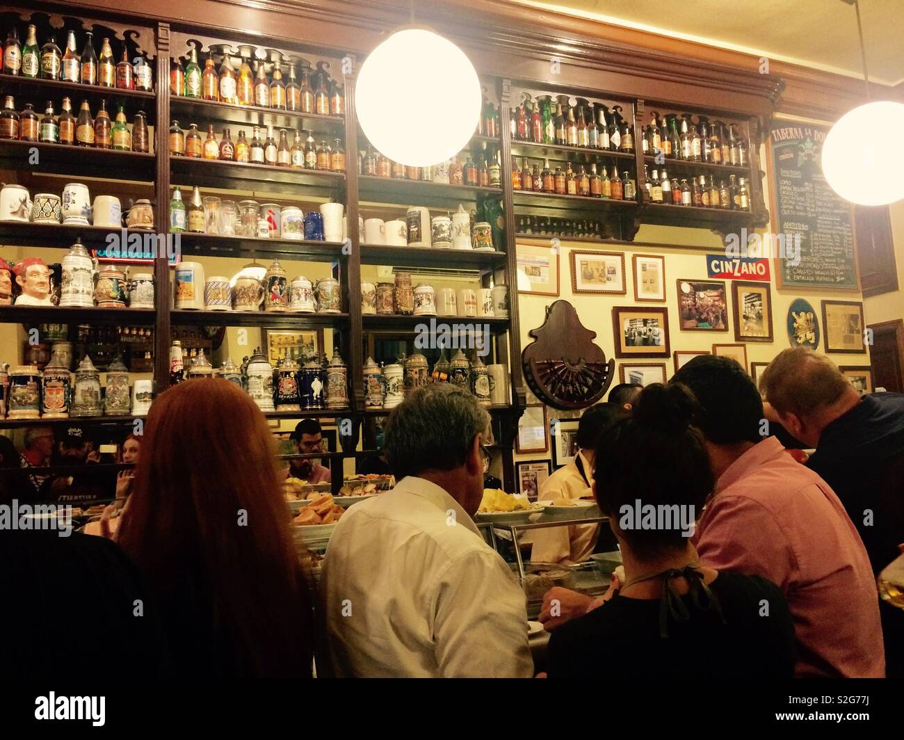People sitting at bar counter in pub in Madrid Spain eating tapas and having drinks Stock Photo