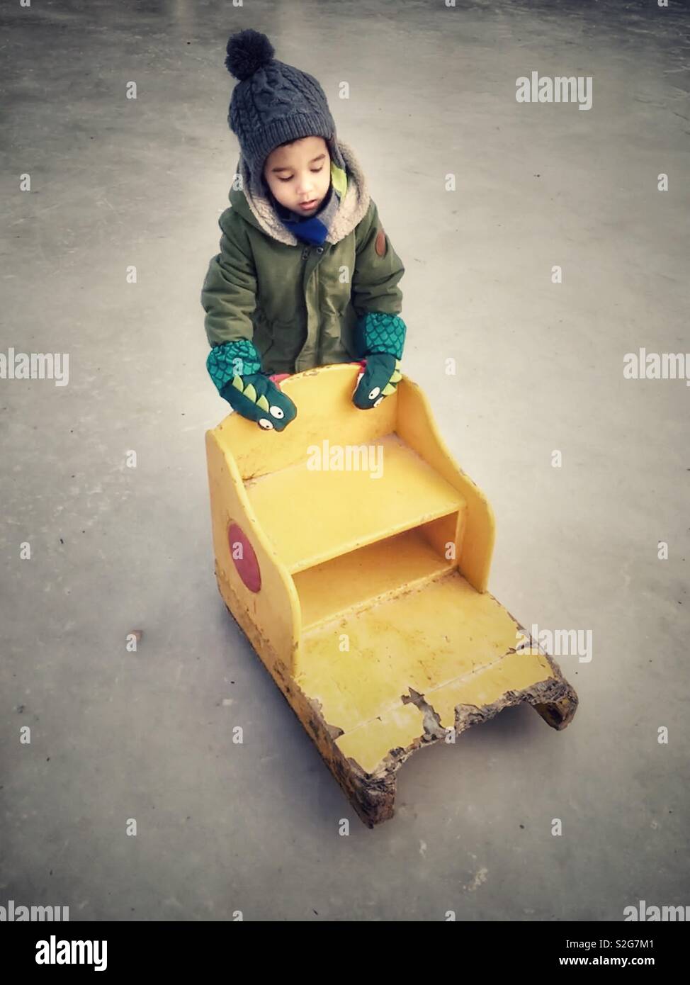 A boy pushing a sledge on a ice rink - Smartphone Captured Stock Image