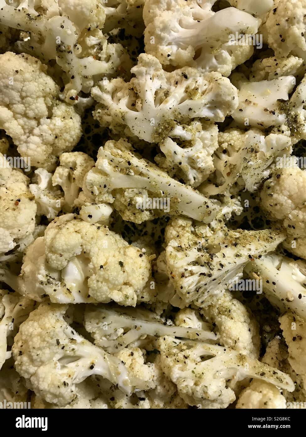 Raw cauliflower with seasoning ready to go in oven Stock Photo Alamy