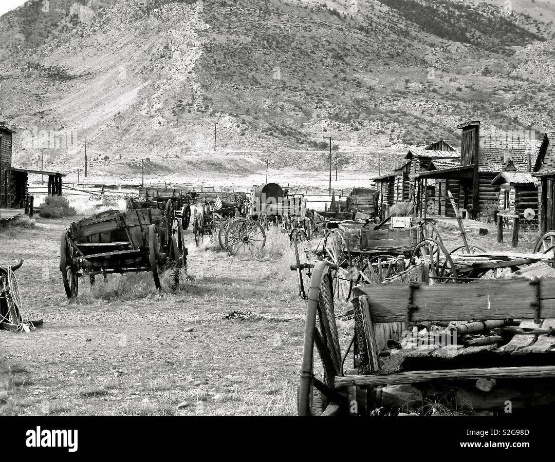 Old western wagons lined up on Main St in Wyoming ghost town. Cody, Wyoming - Smartphone Captured Stock Image
