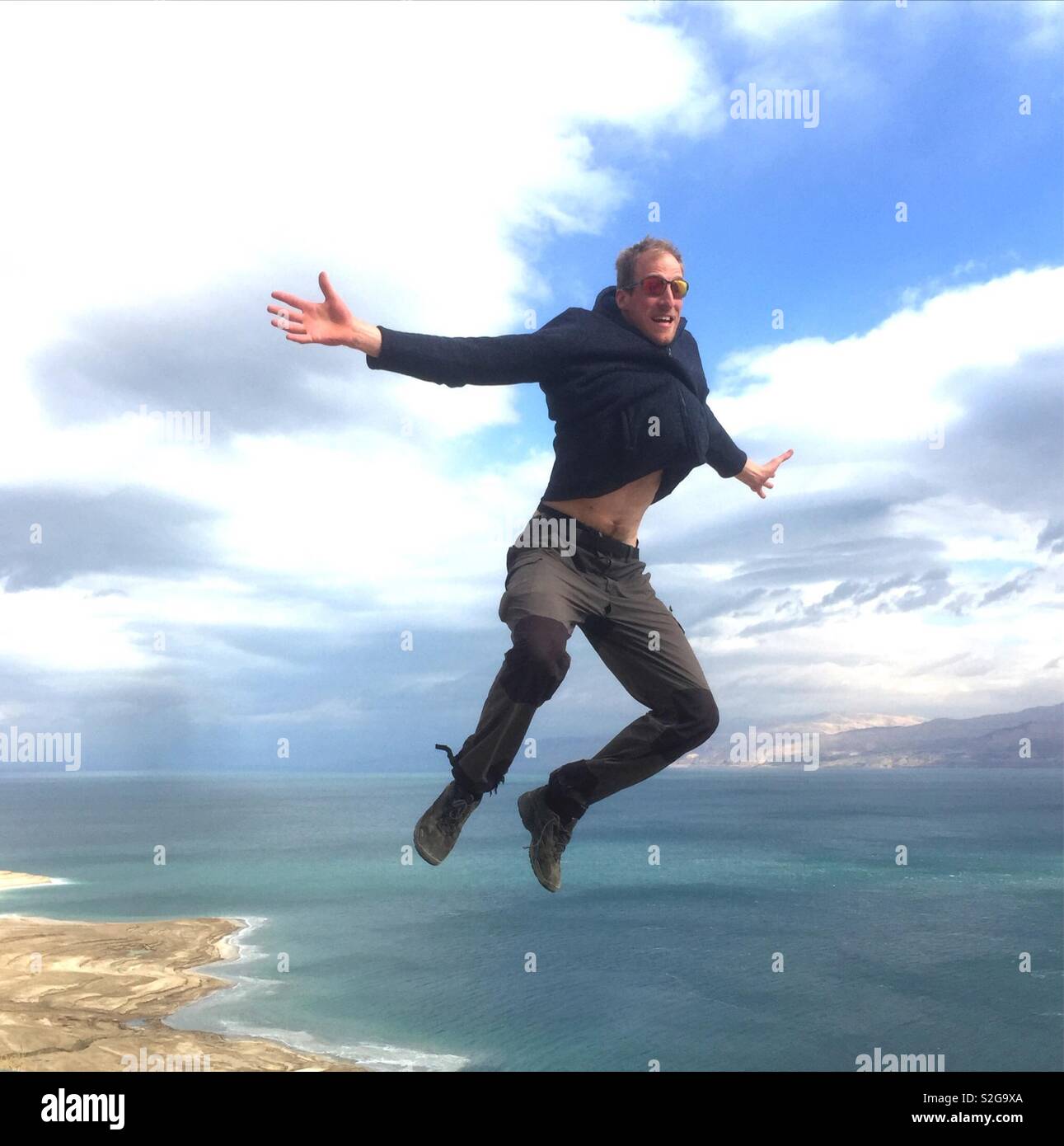 A tourist jumping over the Dead Sea. - Smartphone Captured Stock Image