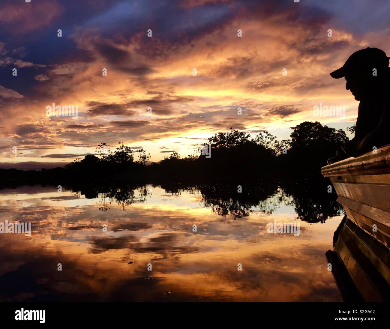 A tourist enjoys a sunset in the Amazon rainforest in the Pacaya-Samiria reserve of Loreto, Peru Stock Photo