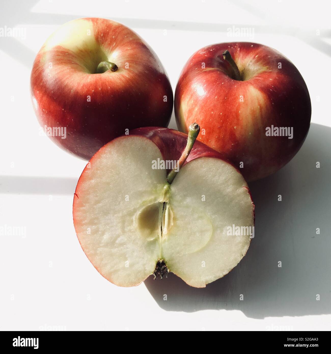 Red Apples Against White Background One Of Them Is Cut In Half Stock Photo Alamy