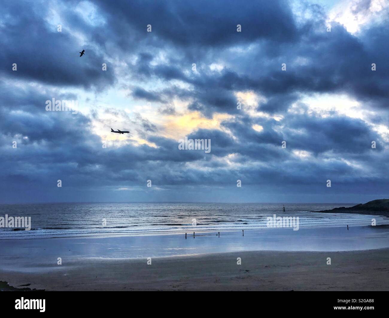 Watchtower Bay, Barry Island, South Wales, with a plane in coming to land at Cardiff airport. Stock Photo