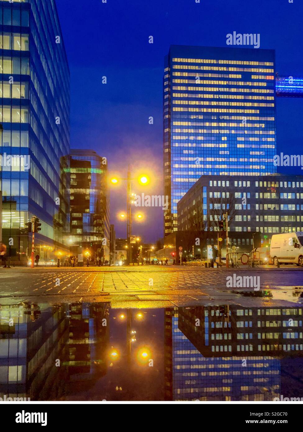 Business offices in the city at Dusk reflected in the water of a puddle on the streets - Smartphone Captured Stock Image