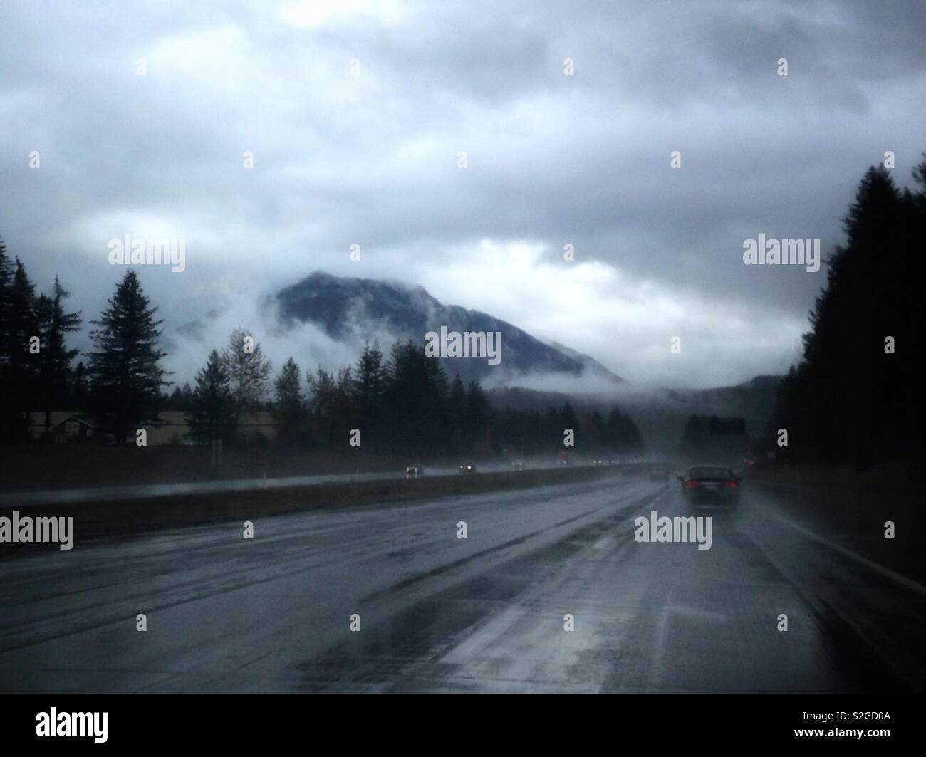 Misty Snoqualmie Mountain near Seattle, Washington, as seen through car windshield on a rainy fall afternoon - Smartphone Captured Stock Image