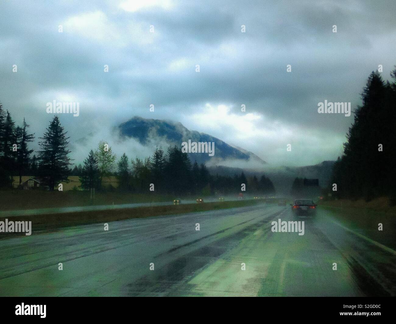 Foggy Snoqualmie Mountain in October on a rainy day, as seen through car windshield - Smartphone Captured Stock Image